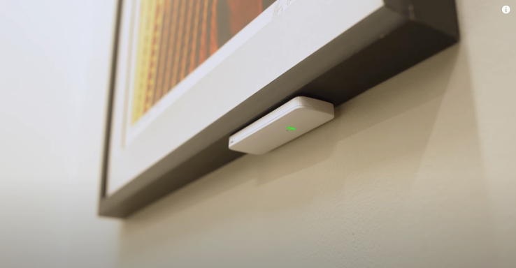Asset sensor shown attached underneath a painting so that it is not easily noticed.