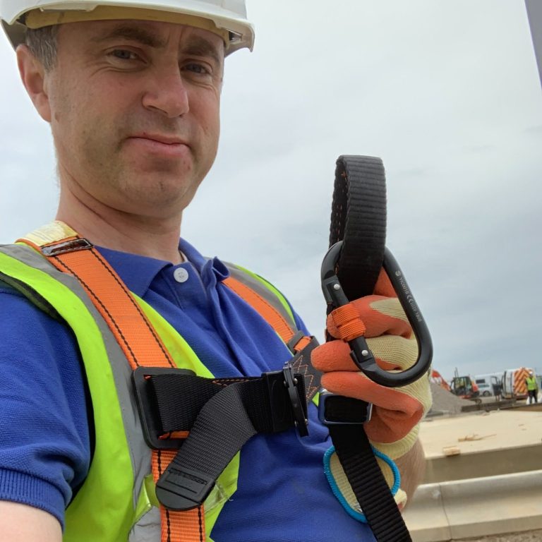 electrician holding safety harness  to indicate the careful and thorough approach to safety, to help you evaluate us