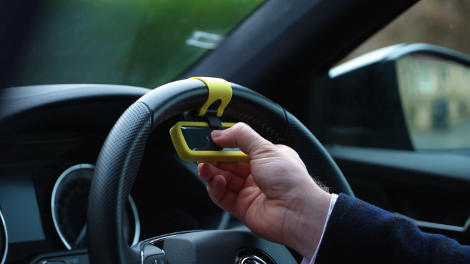 Car Defender motion sensor being attached to steering wheel, visible to potential thieves