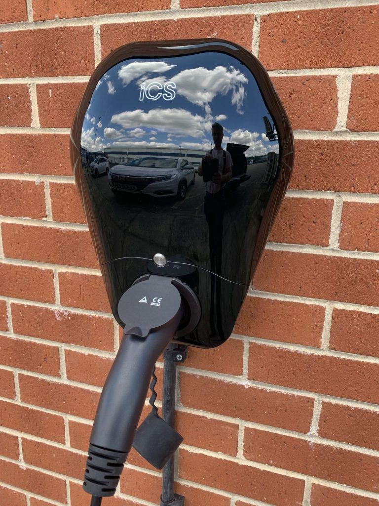 EV Charger installed on wall and vehicle charge cable connected while charge is in progress